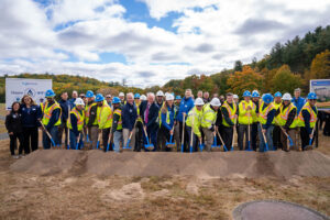 People with ceremonial shovels in front of a dirt pile